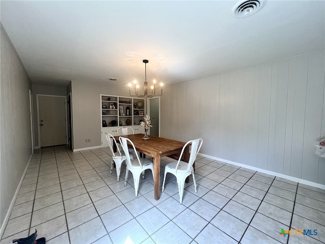 dining area featuring light tile patterned floors, baseboards, visible vents, and a chandelier