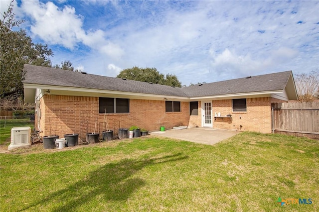 back of property with brick siding, a patio, fence, and a lawn