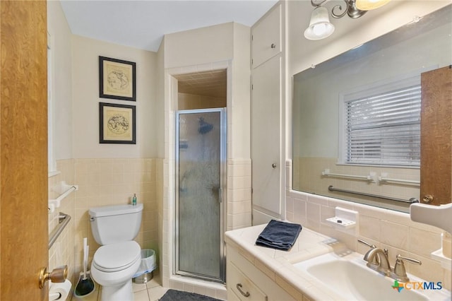 full bath with toilet, a wainscoted wall, vanity, tile walls, and a shower stall