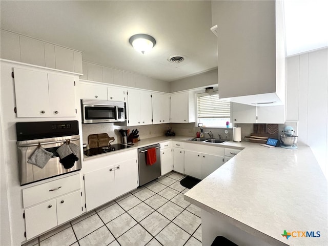 kitchen with visible vents, stainless steel appliances, light countertops, white cabinets, and tasteful backsplash