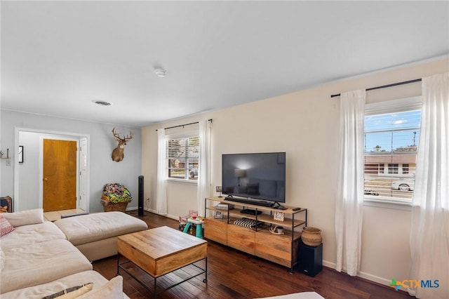 living room featuring visible vents, baseboards, and dark wood-style flooring
