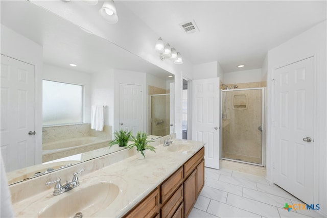 bathroom with vanity and shower with separate bathtub