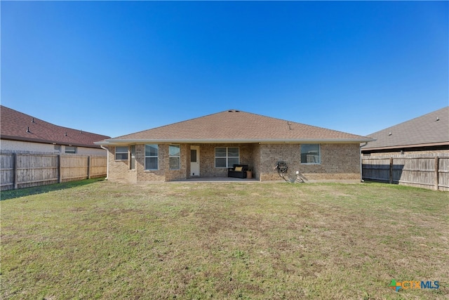 back of house with a yard and a patio