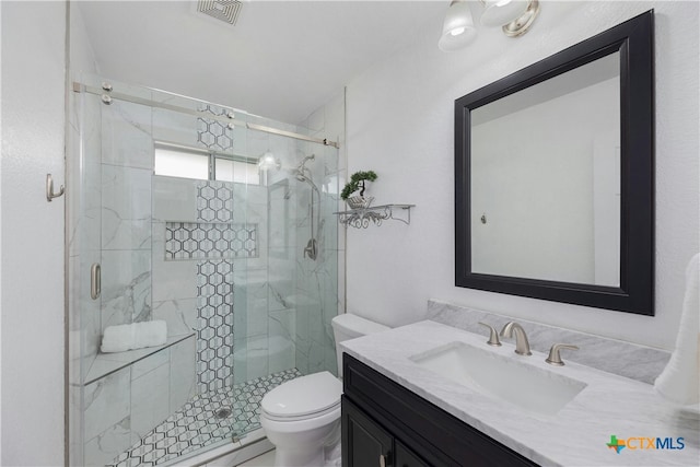 bathroom with vanity, an enclosed shower, and toilet