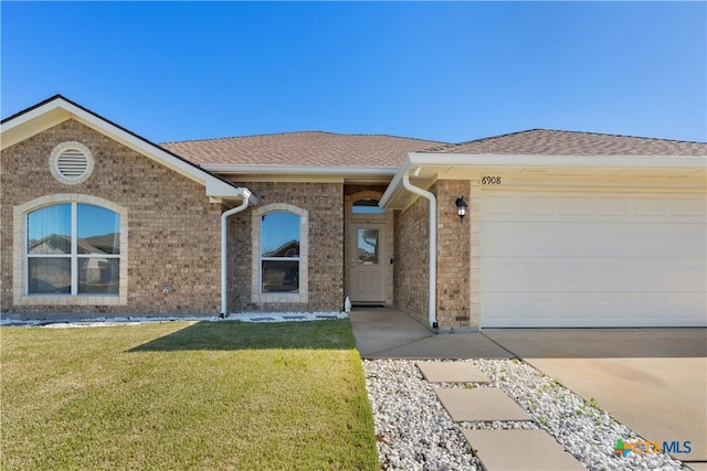 single story home with a garage and a front lawn