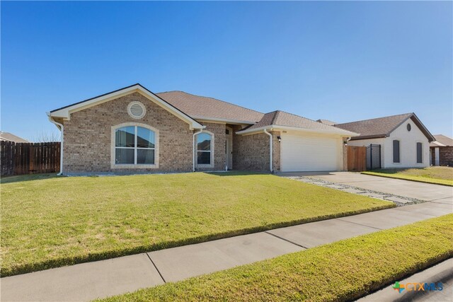 ranch-style home with a garage and a front lawn