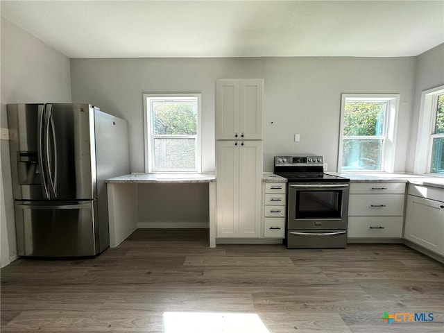 kitchen featuring white cabinets, appliances with stainless steel finishes, and light wood-type flooring