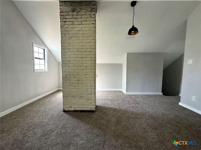 additional living space featuring dark carpet and vaulted ceiling