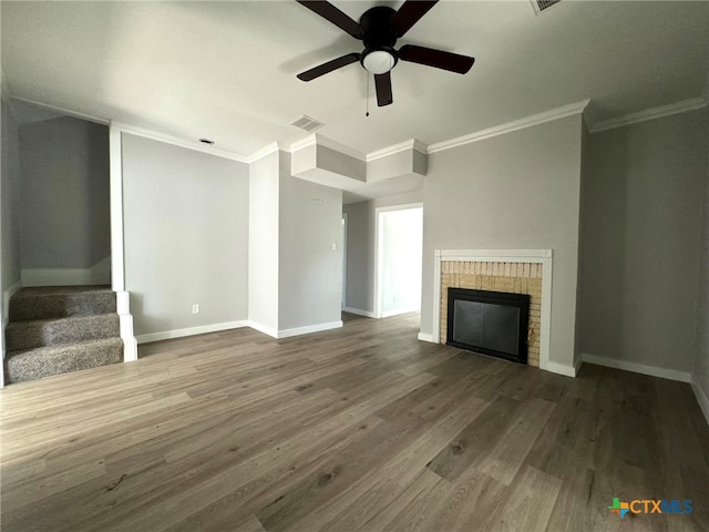 unfurnished living room featuring crown molding, hardwood / wood-style floors, ceiling fan, and a brick fireplace