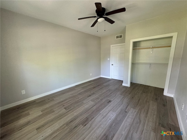 unfurnished bedroom featuring ceiling fan, dark hardwood / wood-style flooring, and a closet