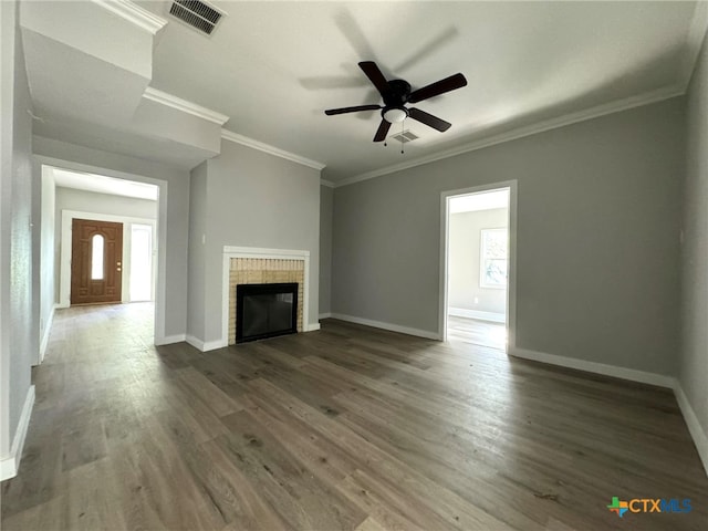 unfurnished living room with a fireplace, dark hardwood / wood-style floors, a wealth of natural light, and crown molding