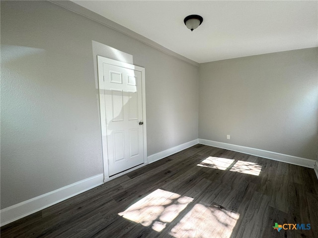 empty room with dark hardwood / wood-style flooring