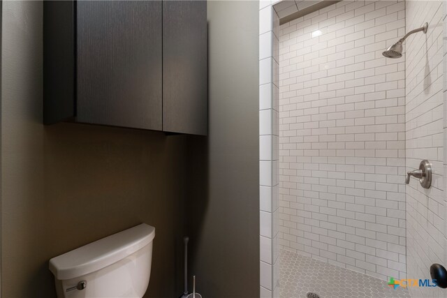 bathroom with toilet and a tile shower