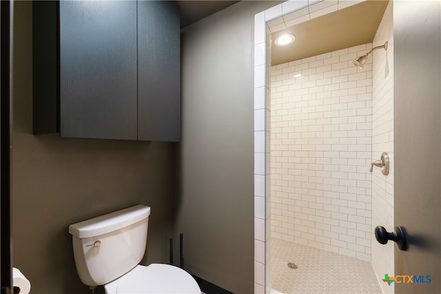 bathroom featuring toilet and a tile shower