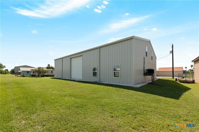 view of outdoor structure featuring a garage and a yard