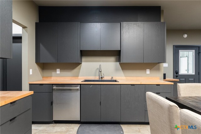 kitchen featuring dishwasher, wooden counters, gray cabinetry, and sink