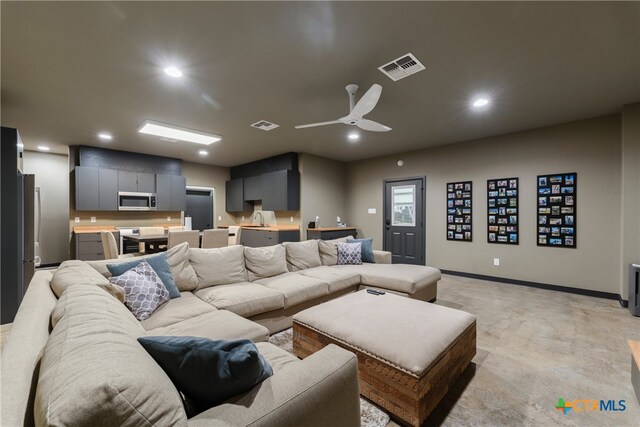 living room with light carpet, sink, and ceiling fan