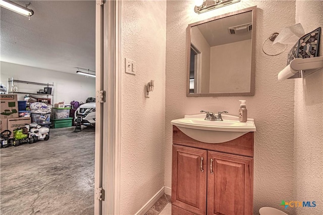 bathroom featuring a textured wall, visible vents, and vanity