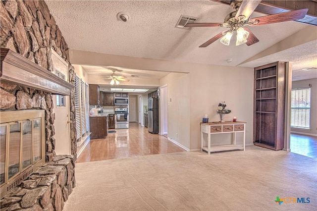 corridor featuring light carpet, baseboards, visible vents, and a textured ceiling