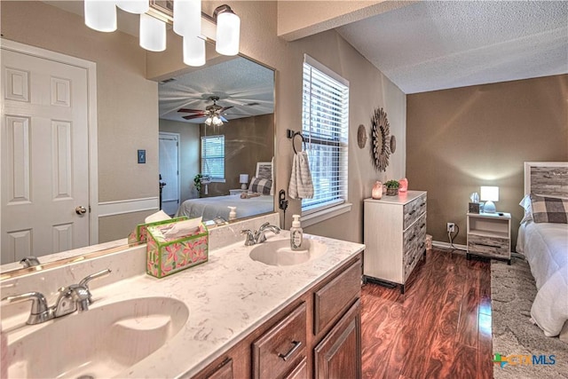 ensuite bathroom featuring ensuite bathroom, wood finished floors, a textured ceiling, and a sink