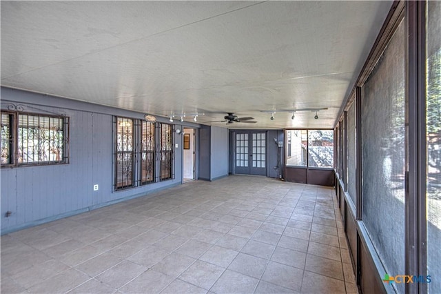 unfurnished sunroom with ceiling fan