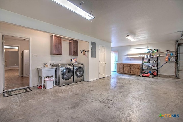 garage featuring a sink, washing machine and dryer, and electric panel