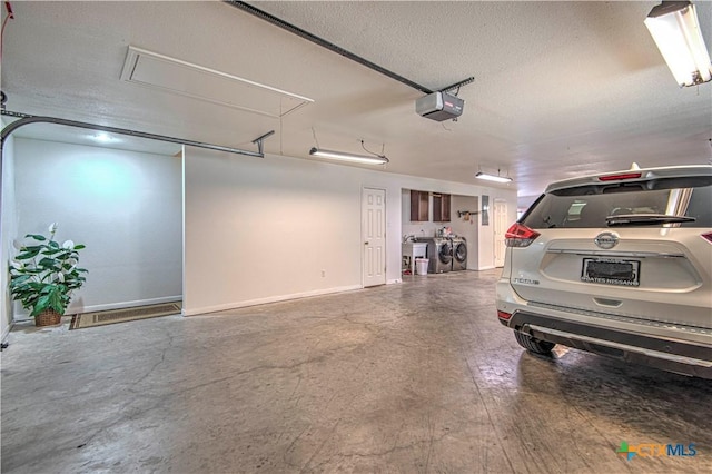 garage with a garage door opener and washing machine and dryer