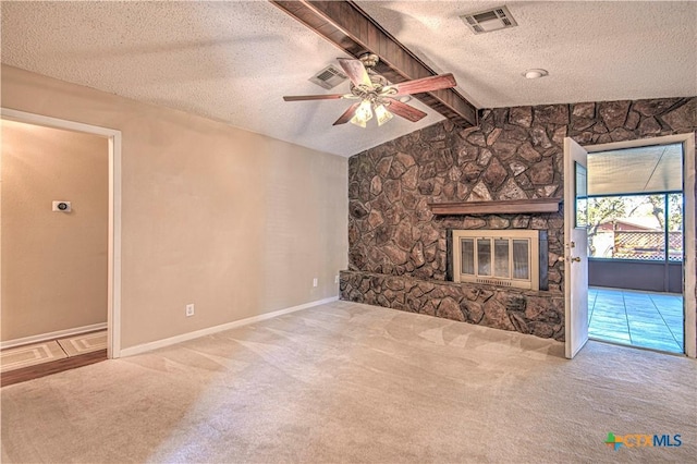 unfurnished living room featuring visible vents, lofted ceiling with beams, a textured ceiling, carpet floors, and a fireplace