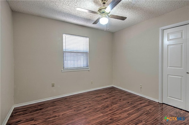 spare room with ceiling fan, a textured ceiling, wood finished floors, and baseboards