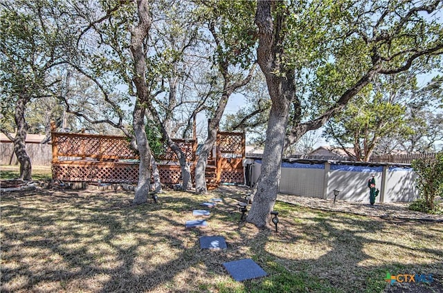 view of yard featuring fence and a deck