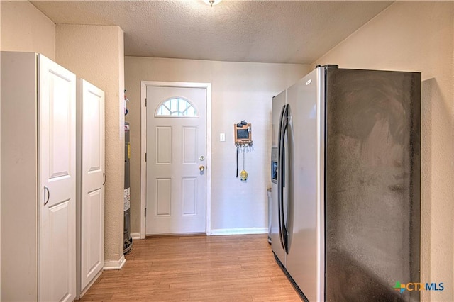 interior space featuring a textured ceiling, baseboards, and light wood-style floors