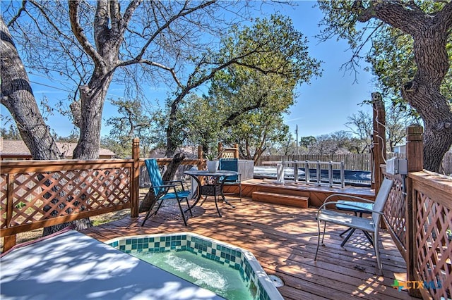 wooden terrace featuring fence and an outdoor hot tub