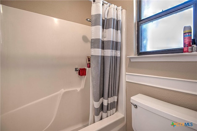 full bathroom featuring toilet and shower / bathtub combination with curtain