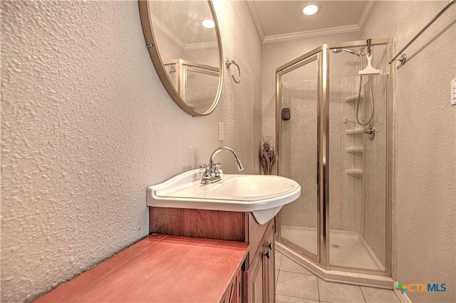 full bath featuring a textured wall, tile patterned floors, a shower stall, and crown molding