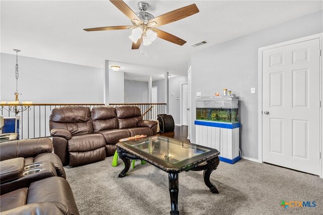 carpeted living room with baseboards, visible vents, and a ceiling fan