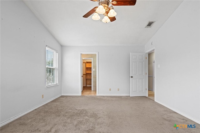 unfurnished bedroom with baseboards, visible vents, light colored carpet, ceiling fan, and ensuite bathroom