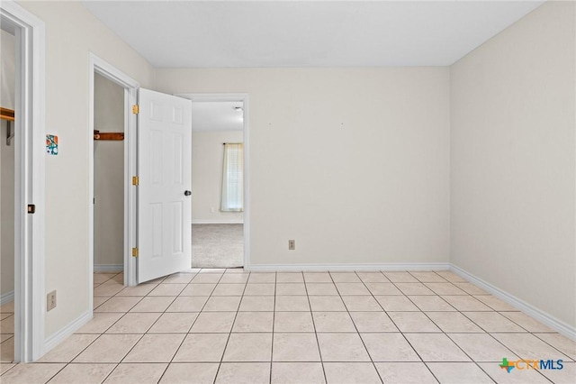 unfurnished room with baseboards and light tile patterned floors