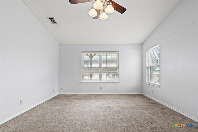 carpeted spare room featuring visible vents, ceiling fan, and baseboards