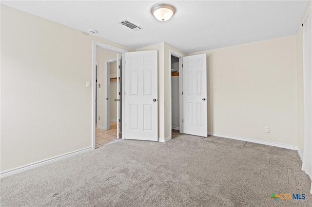 unfurnished bedroom featuring carpet, visible vents, and baseboards