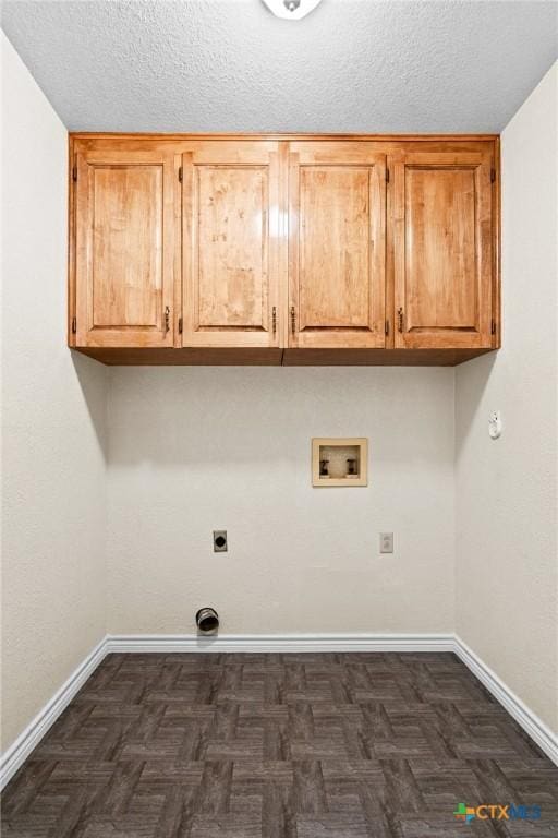 clothes washing area featuring cabinet space, baseboards, a textured ceiling, washer hookup, and electric dryer hookup