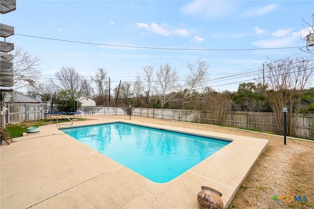 view of swimming pool with a trampoline, a patio area, a fenced backyard, and a fenced in pool