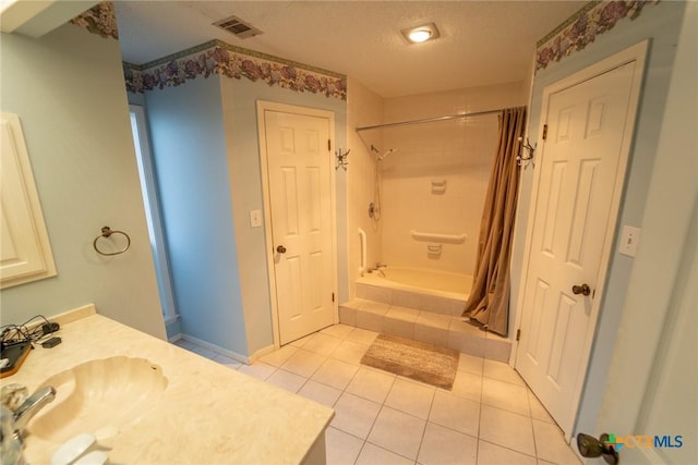 bathroom featuring tile patterned flooring, vanity, and a textured ceiling