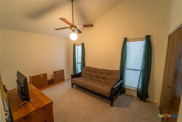 living area with light carpet, ceiling fan, and vaulted ceiling