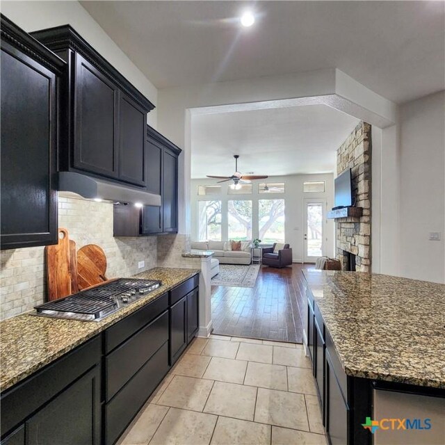 555 Solms Frst, New Braunfels, TX 78132 - kitchen with stainless steel gas cooktop, open floor plan, ceiling fan, and dark stone countertops