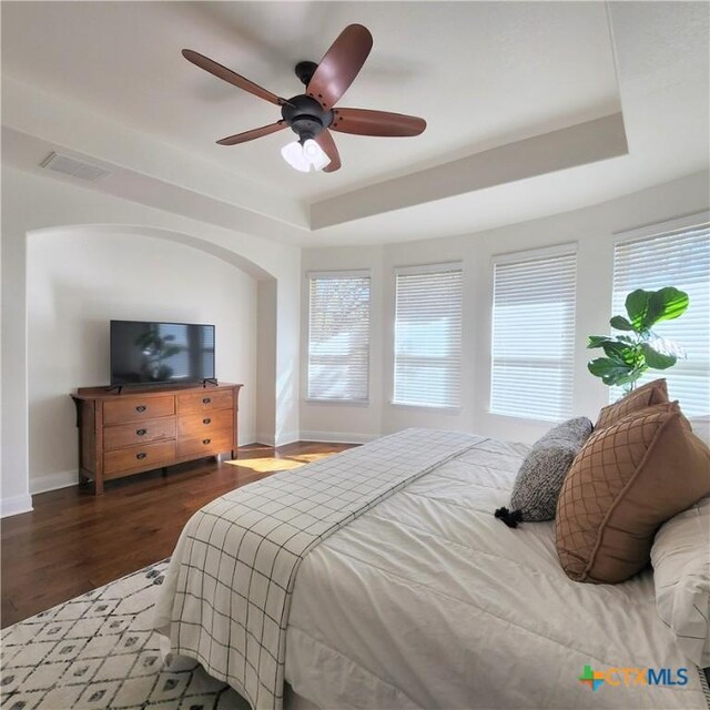 555 Solms Frst, New Braunfels, TX 78132 - bedroom featuring a raised ceiling, baseboards, multiple windows, and wood finished floors
