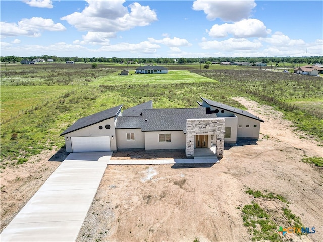 view of front of house with a garage and a rural view