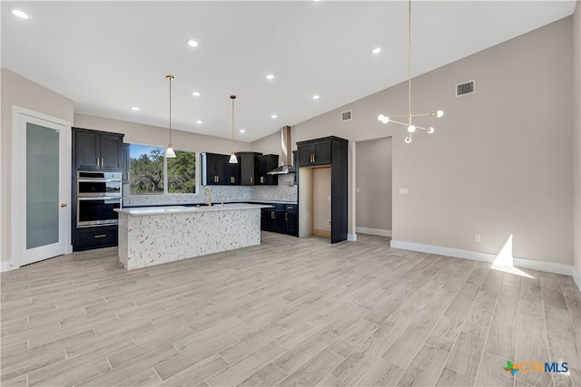 kitchen with stainless steel double oven, light hardwood / wood-style flooring, lofted ceiling, a center island, and wall chimney range hood