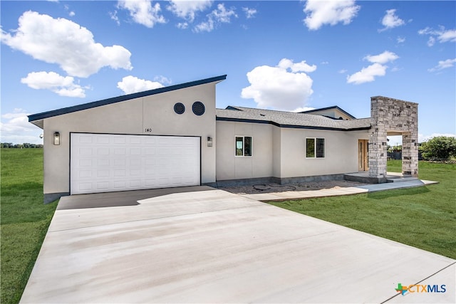 view of front of property with a garage and a front lawn