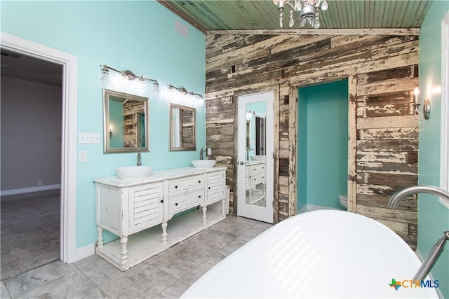 2241 Berger Rd, Temple, TX 76501 - full bath featuring wood walls, a soaking tub, wood ceiling, double vanity, and tile patterned flooring
