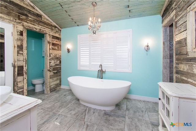 2241 Berger Rd, Temple, TX 76501 - bathroom with wooden walls, vaulted ceiling, a freestanding bath, a chandelier, and toilet